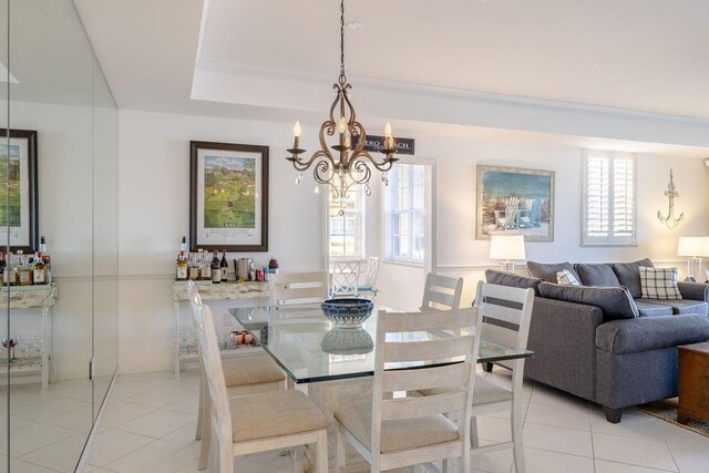 dining area featuring a wealth of natural light, a tray ceiling, light tile patterned flooring, and crown molding