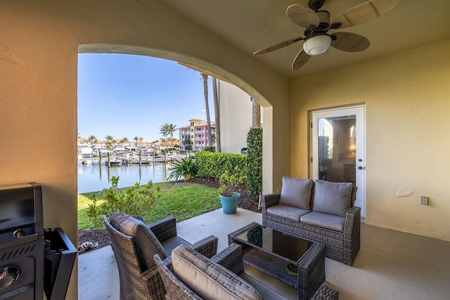 view of patio / terrace with a water view, a ceiling fan, and outdoor lounge area