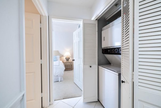 washroom with laundry area, light tile patterned floors, light colored carpet, and stacked washer and clothes dryer