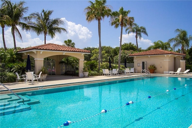 pool with a patio and fence