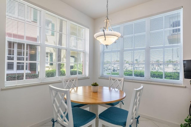 tiled dining area with baseboards and plenty of natural light