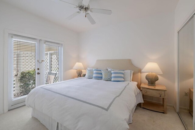 bedroom featuring a ceiling fan, access to outside, french doors, and light carpet