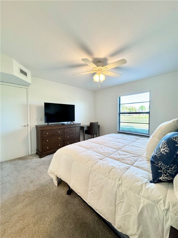 bedroom with light carpet, ceiling fan, and visible vents