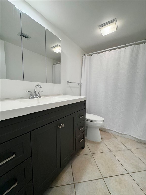 full bathroom featuring visible vents, vanity, toilet, and tile patterned floors