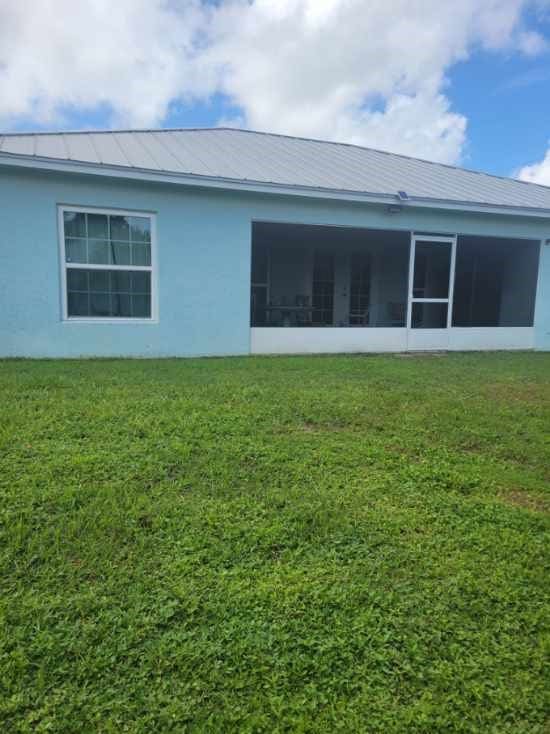 view of side of property featuring a sunroom and a lawn