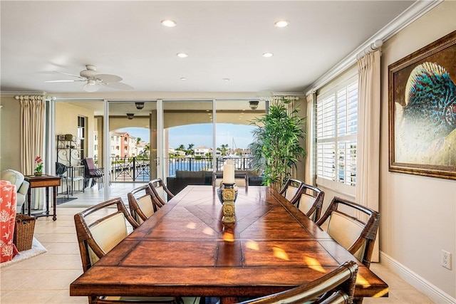 dining area with ceiling fan, light tile patterned floors, and crown molding