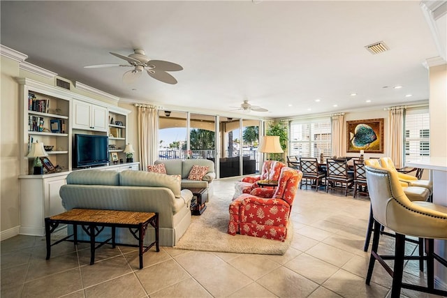 tiled living room featuring ceiling fan and crown molding