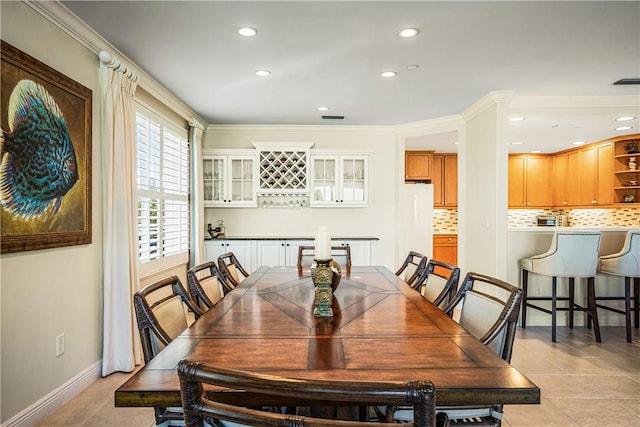 dining space featuring crown molding and light tile patterned floors