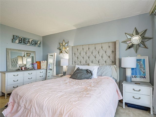 bedroom featuring a textured ceiling and light carpet