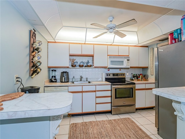 kitchen with white cabinets, stainless steel appliances, sink, and tasteful backsplash