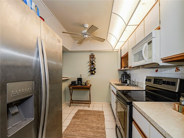 kitchen featuring white cabinetry, decorative backsplash, stainless steel appliances, and light tile patterned flooring