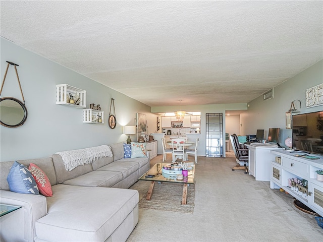 living room featuring light colored carpet, a textured ceiling, and a notable chandelier