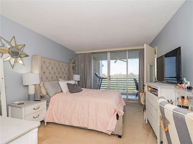 carpeted bedroom with ceiling fan, access to exterior, and a textured ceiling