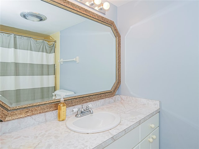 bathroom featuring toilet, a shower with curtain, and vanity