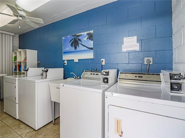 clothes washing area with washing machine and dryer, ceiling fan, and light tile patterned floors