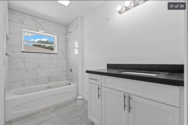 bathroom with vanity and tiled shower / bath