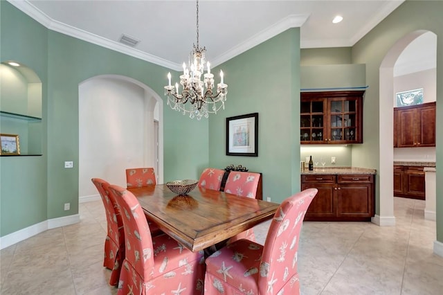 1300 Lake Bend Ct, Vero Beach, FL 32963 - dining area with arched walkways, crown molding, light tile patterned floors, a chandelier, and baseboards