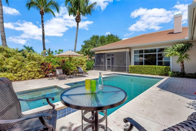 1300 Lake Bend Ct, Vero Beach, FL 32963 - view of pool with a sunroom, a patio area, and a pool with connected hot tub