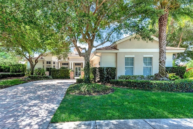1300 Lake Bend Ct, Vero Beach, FL 32963 - view of front facade featuring decorative driveway, a front yard, and stucco siding