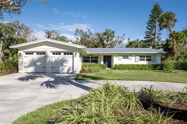 ranch-style home featuring a front yard, stucco siding, concrete driveway, a garage, and metal roof