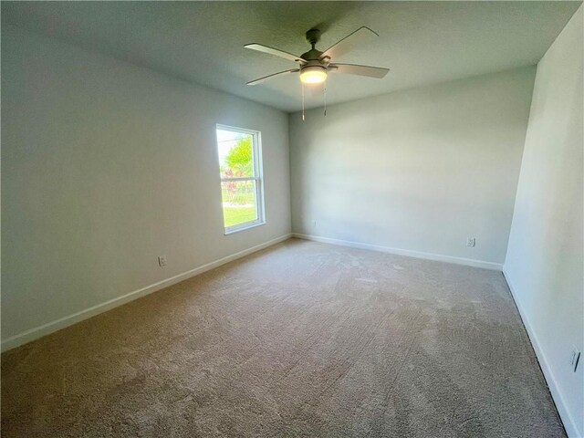 empty room featuring ceiling fan, carpet, and baseboards