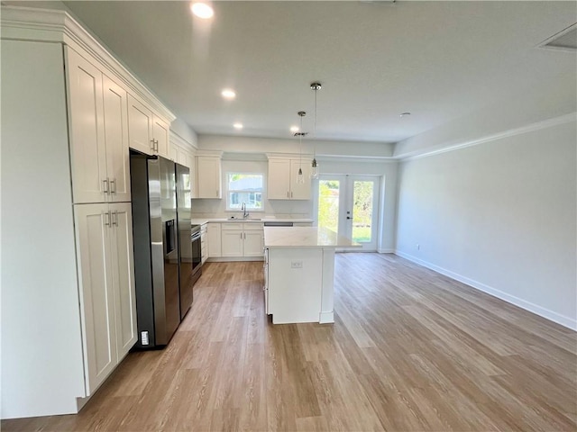 kitchen with white cabinets, light wood finished floors, stainless steel refrigerator with ice dispenser, and light countertops