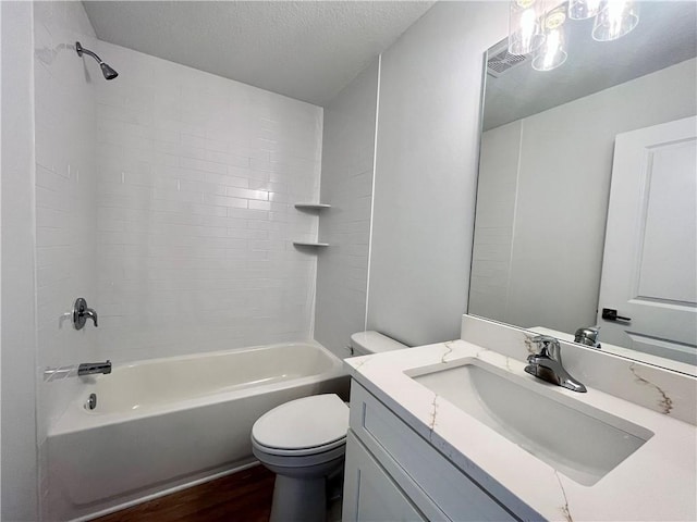 bathroom featuring visible vents, toilet, wood finished floors, tub / shower combination, and vanity