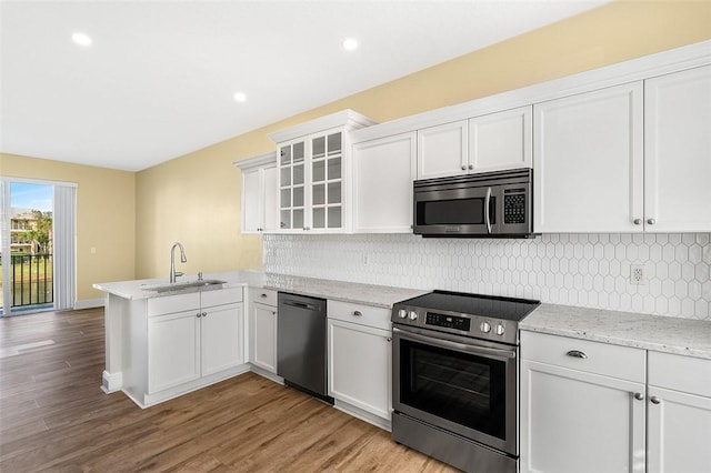 kitchen with white cabinetry, sink, stainless steel appliances, and kitchen peninsula