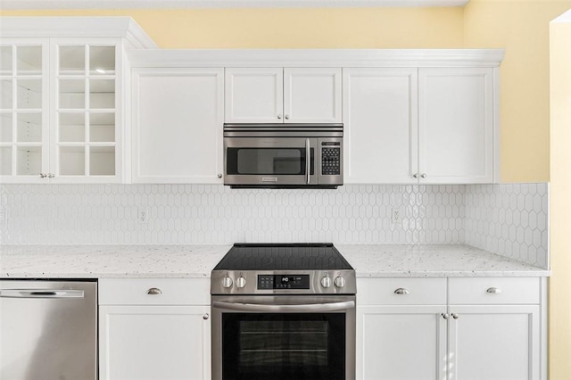 kitchen with white cabinetry, light stone counters, and stainless steel appliances