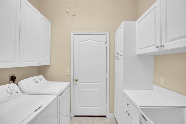 clothes washing area featuring washer and dryer and cabinets