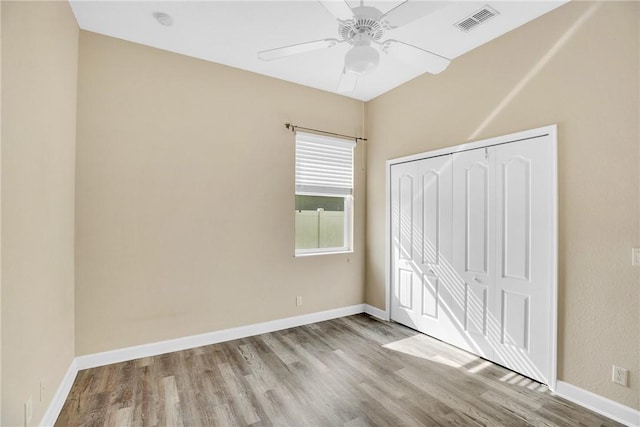 unfurnished bedroom with ceiling fan, a closet, and light hardwood / wood-style flooring