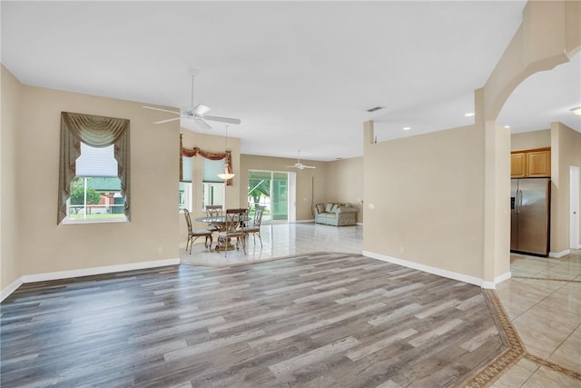 unfurnished living room featuring ceiling fan, light hardwood / wood-style flooring, and a healthy amount of sunlight