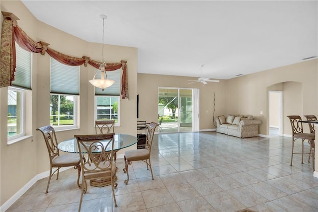 dining space featuring ceiling fan, light tile patterned flooring, and a healthy amount of sunlight