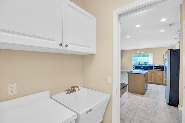 laundry area featuring sink and light tile patterned flooring