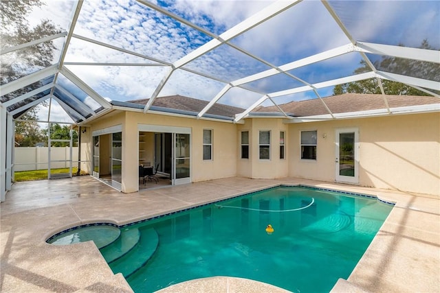 view of swimming pool featuring glass enclosure and a patio