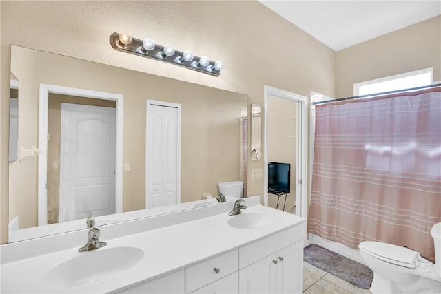 bathroom with toilet, vanity, and tile patterned floors