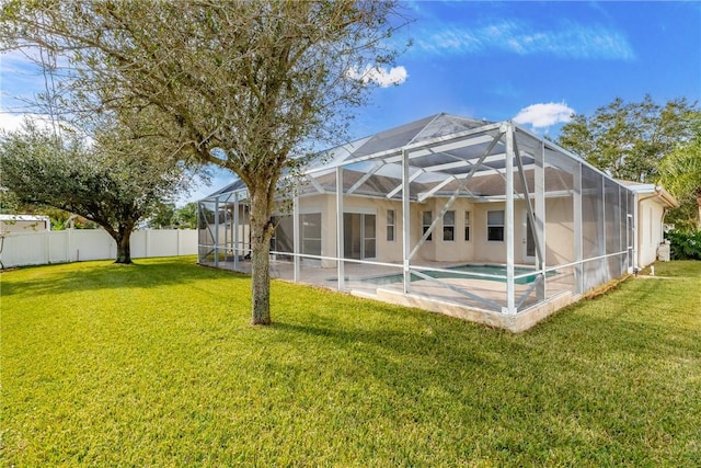 back of house with a lanai, a fenced in pool, a yard, and a patio