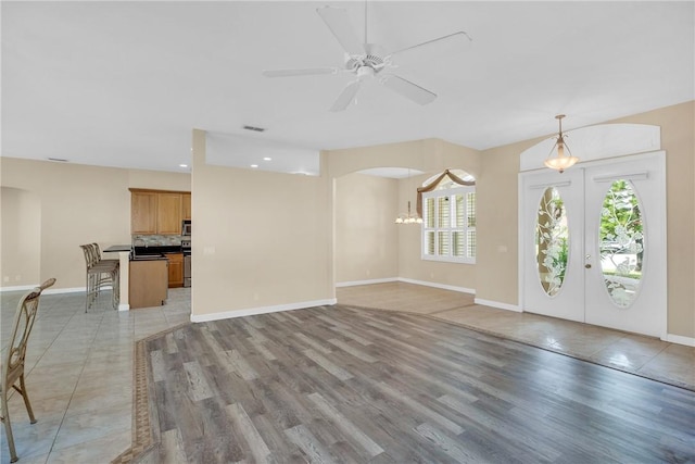 foyer entrance featuring light wood-type flooring, ceiling fan, plenty of natural light, and french doors