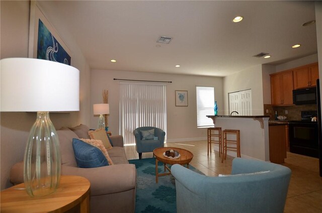1073 Cheval Dr, Vero Beach, FL 32960 - living room with light tile patterned floors, recessed lighting, and baseboards