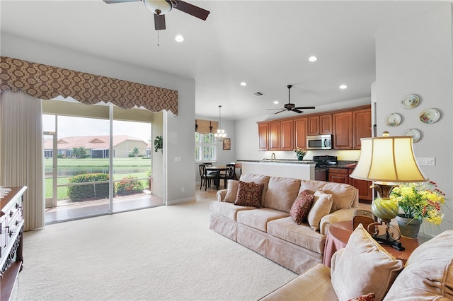 living room with light colored carpet, ceiling fan, and sink