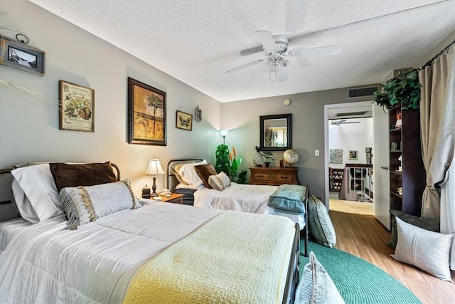 1170 6th Ave Unit 9D, Vero Beach, FL 32960 - bedroom with wood finished floors, a textured ceiling, and a ceiling fan