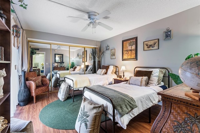 bedroom featuring ceiling fan, a closet, wood-type flooring, and a textured ceiling