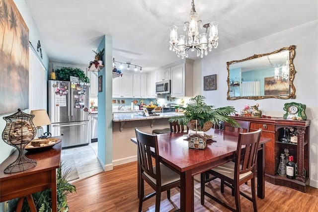 1170 6th Ave Unit 9D, Vero Beach, FL 32960 - dining space featuring light wood-type flooring and a chandelier