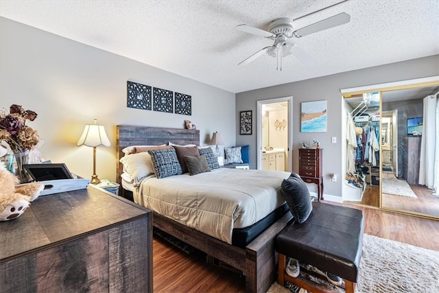 bedroom featuring dark wood-type flooring, ceiling fan, a textured ceiling, connected bathroom, and a closet