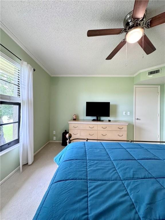 bedroom featuring light carpet, a textured ceiling, ceiling fan, and crown molding