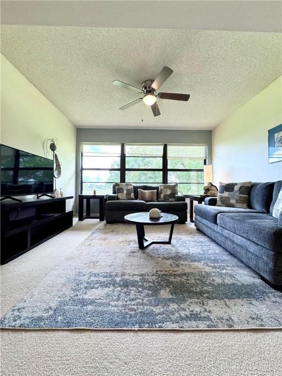 carpeted living room with a textured ceiling and ceiling fan