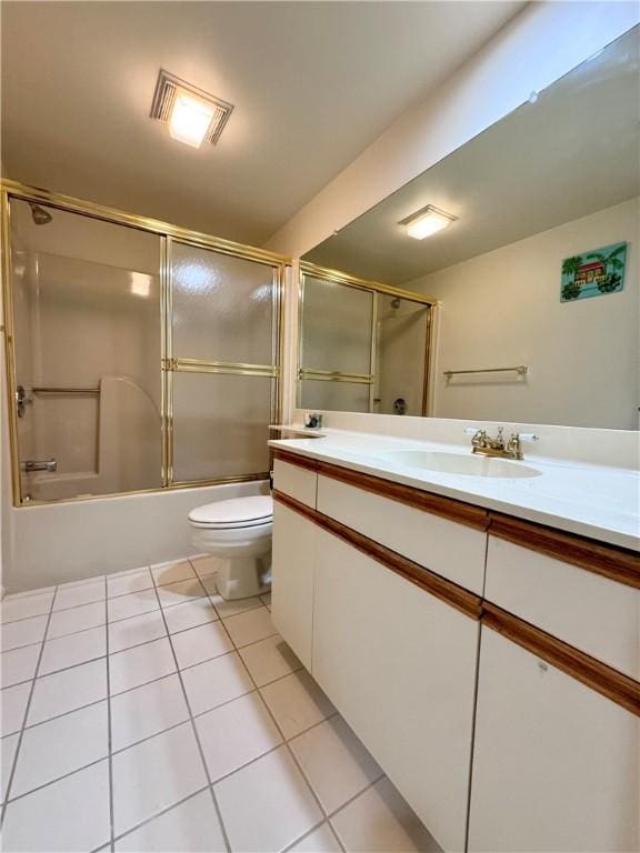 full bathroom with tile patterned floors, toilet, vanity, and combined bath / shower with glass door