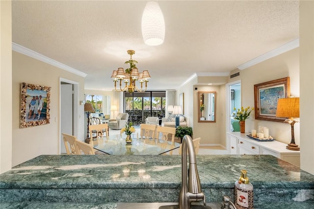 dining room with crown molding, a chandelier, and a textured ceiling