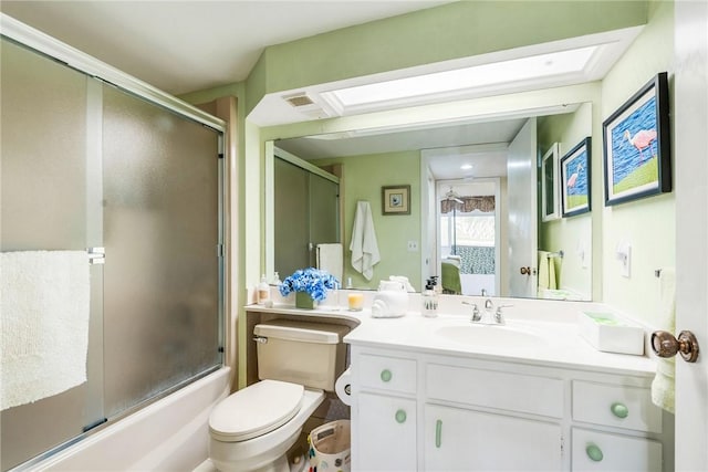 full bathroom featuring vanity, shower / bath combination with glass door, and toilet