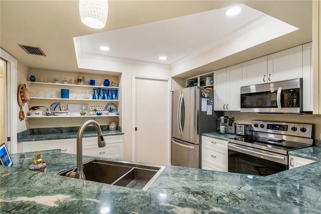 kitchen featuring stainless steel appliances, sink, white cabinets, and dark stone counters